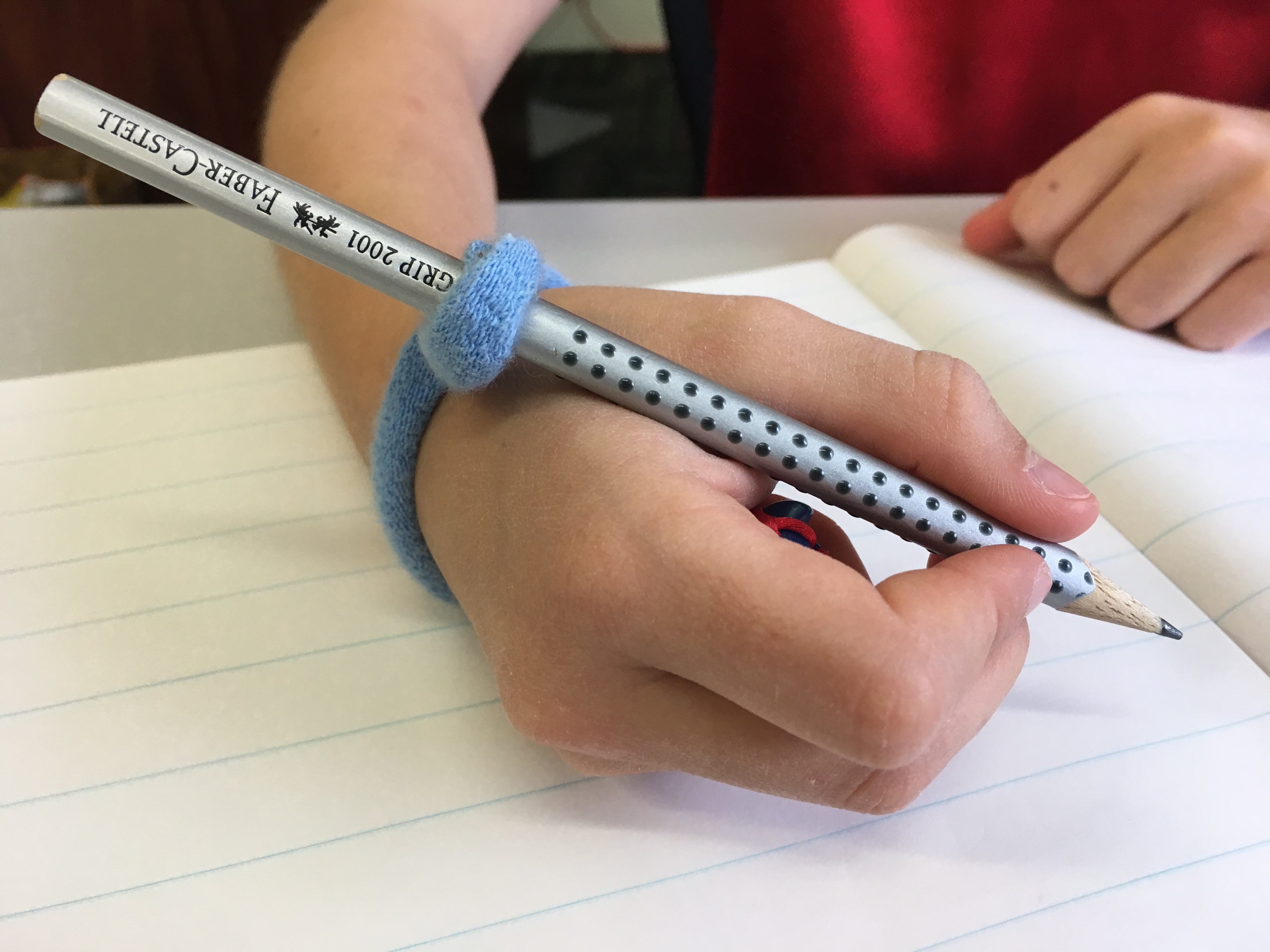 Pencil grip with string attached